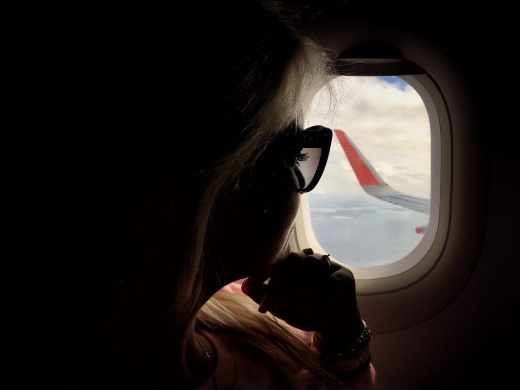 1632435428 290 uma garota milenar sentada perto da janela em um avião enquanto viaja t20 mo407m